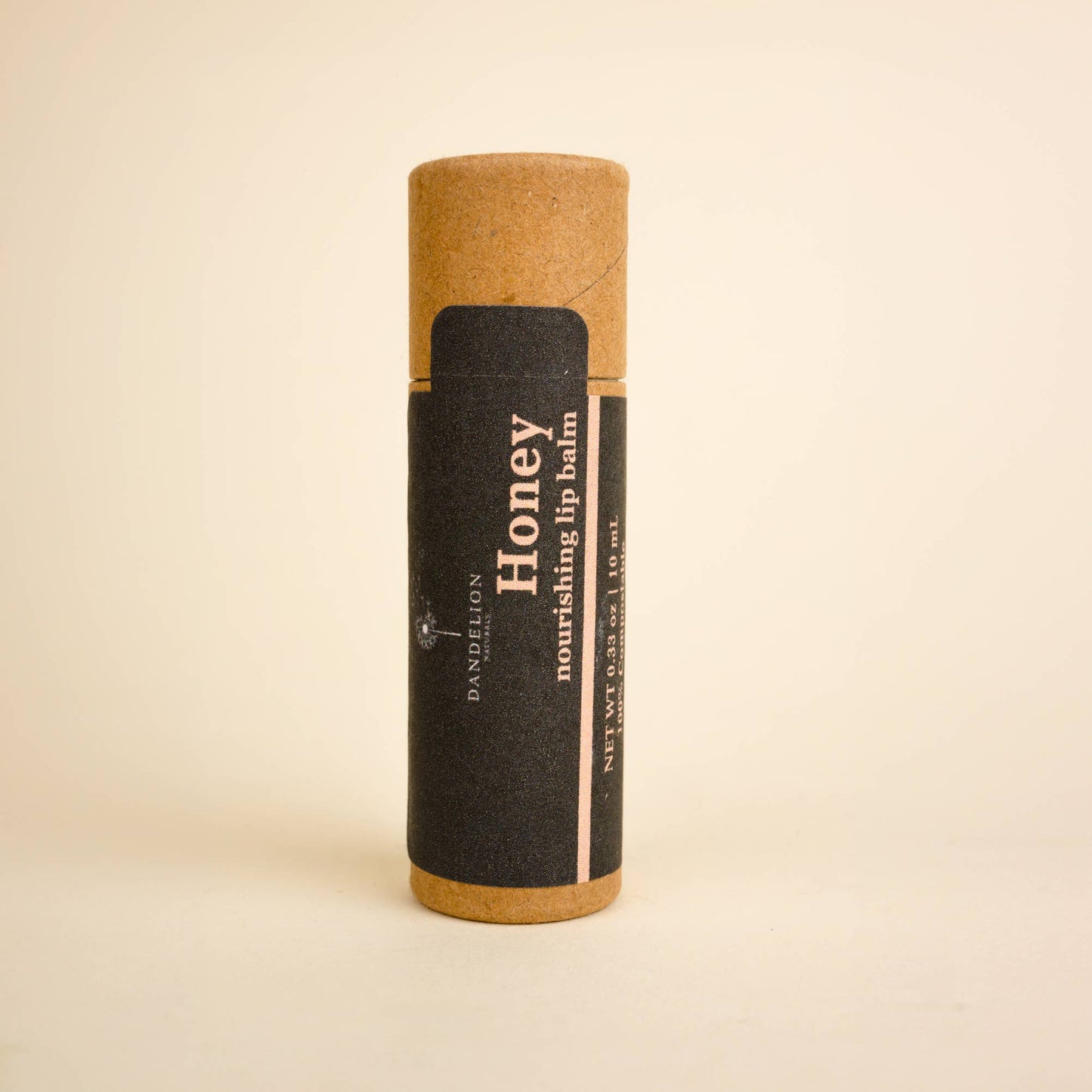 Dandelion Honey nourishing lip balm in eco-friendly brown tube with black label, natural skincare product