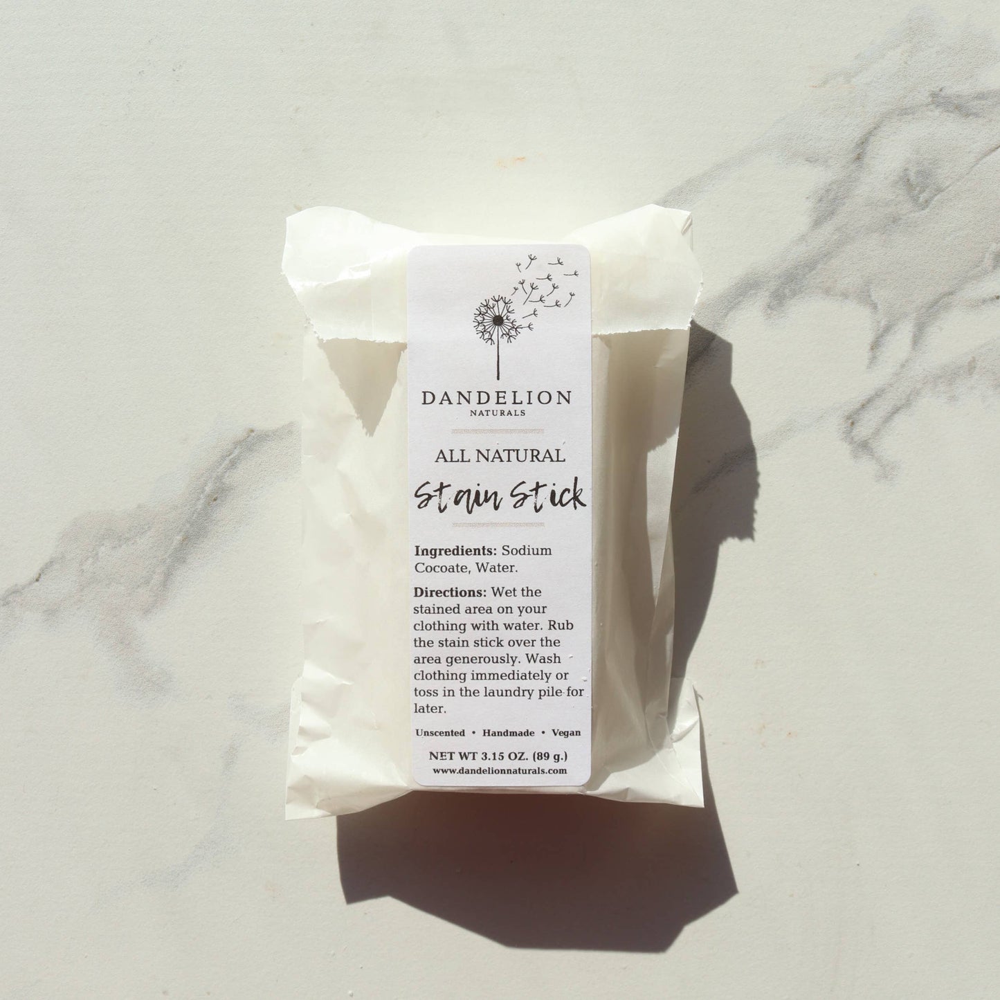 Dandelion Naturals all natural stain stick with ingredients and directions on white packaging on marble surface