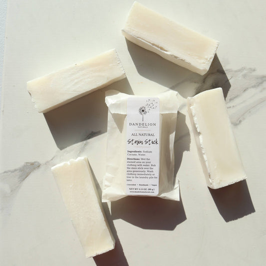 Dandelion Naturals all natural stain stick with five white soap bars on marble surface